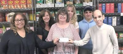 Glenn P. Dickes, director of the Warwick Ecumenical Food Pantry, accepts a donation to the food pantry from the Warwick Town Democratic Committee's treasurer, Patricia McMillan.