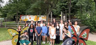 Summer Youth Leadership Academy students and artist Amy Lewis Sweetman pose with their butterfly chair creations.
