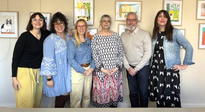 Lisa Cullen, center, newly selected Village of Warwick Artist-in-Residence, stands with (left to right) Aliza Schiff, Village of Warwick special projects coordinator; Nicole Hixon, former AIR; Melissa Shaw-Smith, Wickham Works executive director; Mayor Michael Newhard; and Village Trustee Mary Collura in front of an exhibit of Cullen’s work at the Albert Wisner Library. Library Director Lisa Laico also served on the jury to select the 2026-2027 AIR.
