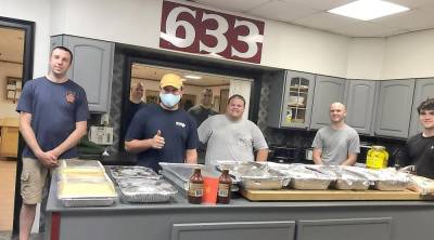 Members of the Warwick Fire Department pose with Connor Wilson (center) of Smokin Grate BBQ for a dinner organized by Small Things Inc. Photo provided by Tracy Gregoire.