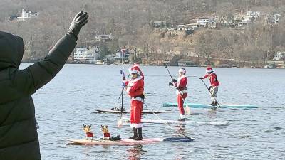 Paddleboarders dressed as Santa take part in the ninth annual Santapalooza on Sunday, Dec. 4 on Greenwood Lake.