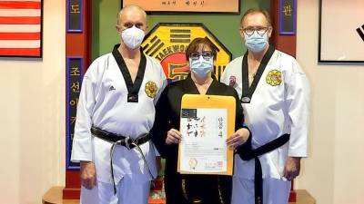 Patti Lurye-Dempster (center), joined by Grandmaster Doug Cook (left) and her husband, Dr. David Dempster, recently earned the 4th degree Master black belt in traditional taekwondo.
