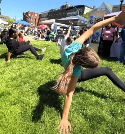 Youngsters do yoga on the Railroad Green lawn.