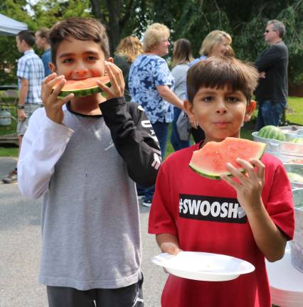 Photos by Roger Gavan Edward Santiago, 10 and his brother Evan, 8, enjoy slices of watermelon.