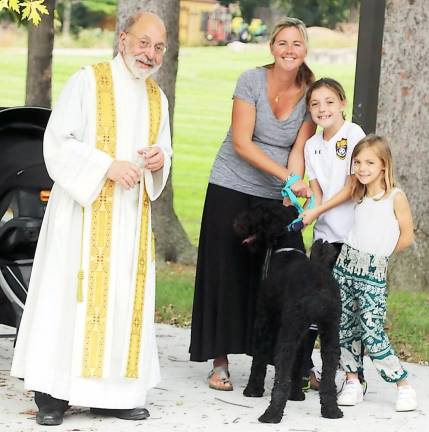 After the blessing St. Stephen’s pastor, the Rev. Jack Arlotta. posed for a photograph with Amanda Lopez, her children Nora, 9, Penelope, 5, and their pet Cooper, a Standard Poodle.