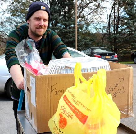 Volunteers, like Mike O'Keefe, used shopping baskets and carts to rush final food donations into the building where they were inventoried, stacked on shelves and repackaged for delivery.