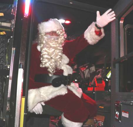 Santa, traveling in a modern fire apparatus, made his usual early surprise visit and handed out goodies to the excited children who lined up to greet him.