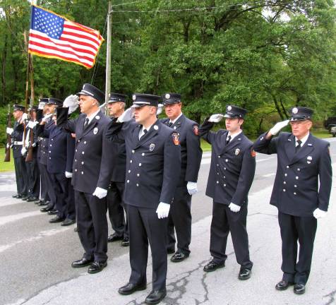 Members of the Warwick Fire Department present arms during the playine of the National Anthem..