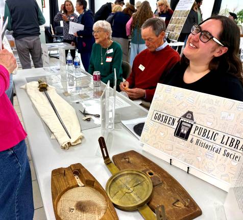 Goshen Public Library &amp; Historical Society representatives Ann Roche (local history librarian), Donovan Aitchison, and Elizabeth DiGiorgio share Revolutionary War-era artifacts from the library’s archives, including an authentic sword and compass from the era.