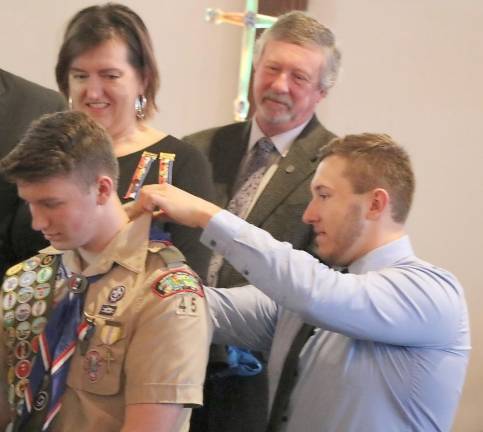 During the Presentation of the Eagle Badge, Eagle Scout Jason Hranitz placed the scarfs on the three new Eagle Scouts, including his younger brother Maxwell Hranitz (pictured here) as parents look on.
