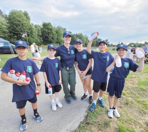 Warwick Police Officer Katie Oresto (center) and several children from the Warwick Junior Police Academy hand out water bottles during ‘National Night Out.’