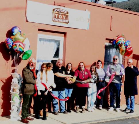 On Saturday, Nov. 20, Mayor Michael Newhard (left) and members of the Warwick Valley Chamber of Commerce joined owners Wayne and Wendy Davidovitch (center) and their family members, who also serve as staff, to celebrate the occasion with a ribbon cutting. Photo by Roger Gavan.