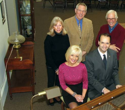 Photo by Roger Gavan Gathered around the antique baby grand piano at the A.W. Buckbee Center to formalize plans for the Jan. 24 business mixer are: seated from left, Warwick Valley Chamber of Commerce Programs Chair Janine Dethmers and Chamber of Commerce President Paul Rafanello. Standing, from left: Town of Warwick Historical Society Volunteer of Fundraisers and Events Jane Glazman, Warwick Valley Chamber of Commerce Executive Director Michael Johndrow and Town of Warwick Historical Society President Michael Bertolini.