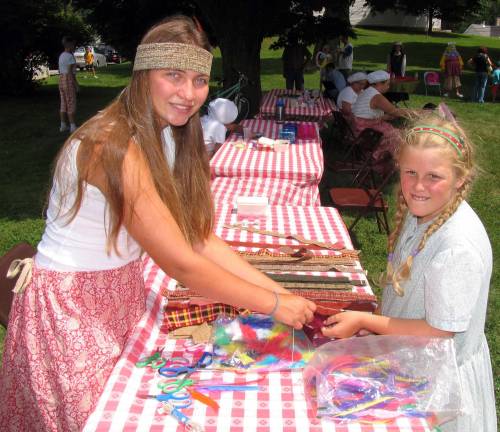 Sarah Lalumiere, 16, and Loretta Kurtz, 10, crafting Native American headdress.