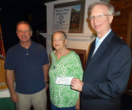 Photos by Stan Martin Rotary President Neil Sinclair presents a check to Michelle Carter, director of the Warwick Ecumenical Food Pantry, and Charles Hemstredt, Warwick Food Pantry manager. Carter said she is seeking support from Rotarians and the Warwick community to provide Thanksgiving and Christmas dinners for needy Warwick families and seniors living alone.