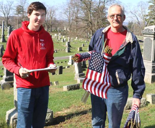 Helping the veterans place flags at Warwick Cemetery are Troop 45 Scout Matthew Kaytes and Troop Committee Chair Jay Domeseck.