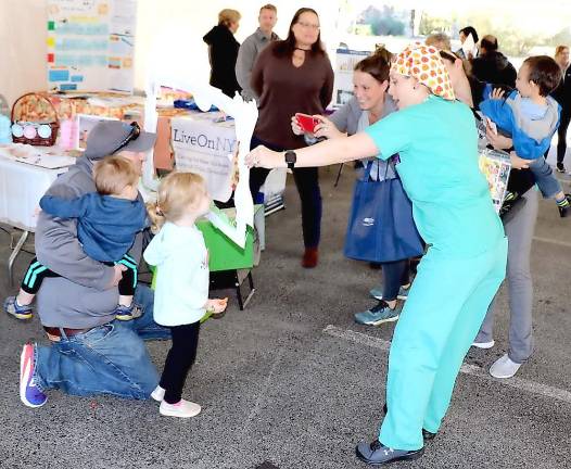 Alisa Adams from Surgical Services directs an “Are you a St. Anthony Baby?” photo for the family.