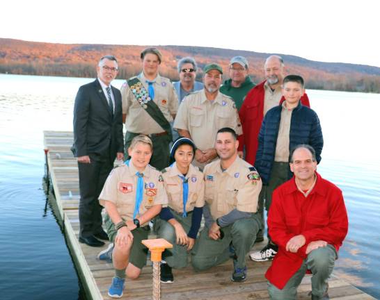 Photo by Roger Gavan On Thursday, Nov. 16, Troop 45 Boy Scout Alexander Brand (rear between Town of Warwick Supervisor Michael Sweeton (left) and his father, Troop 45 Scoutmaster Kevin Brand,) was joined by Warwick Councilman Russ Kowal, Assistant scoutmasters and scouts as he presented his completed project, a dock and improved parking area at the Town of Warwick public boat launch on Wickham Lake to Sweeton.