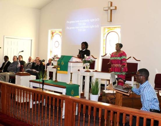 The Rev. Ann Marie Bentsi-Addison Posey (center), pastor of the Warwick Union African Methodist Episcopal Church, led the congregation in the National Anthem, the Call to Justice and Community and the opening hymn, &#x201c;Lift every voice and sing,&#x201d; by James Weldon Johnson.