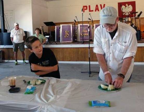 Travis Coleman looks on as Mike Sweeton prepares his onion for the contest.