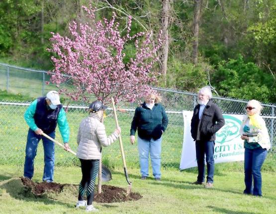 The ceremony concluded with everyone invited to pick up the ceremonial shovel and toss some fresh soil on the new tree.