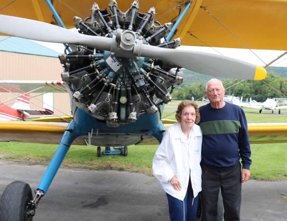 Special guest speaker Kathleen Hilbrand, 93, who served in World War II as a member of the Women Airforce Service Pilots (WASP) poses with Airport Manager Dave Mac Millan in front of a PT 17, a WW II US Army primary pilot trainer, which was one of the planes she flew.