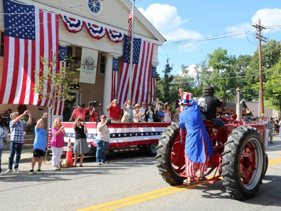 Uncle Sam arrives by tractor at the parade.
