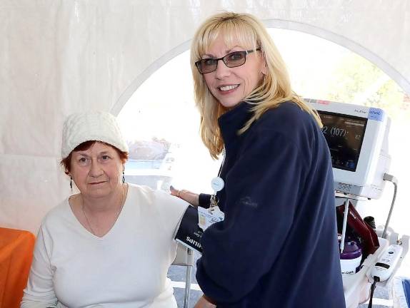 Peg Ross takes an opportunity to have her blood pressure tested by Jeremy Quinn, RN.