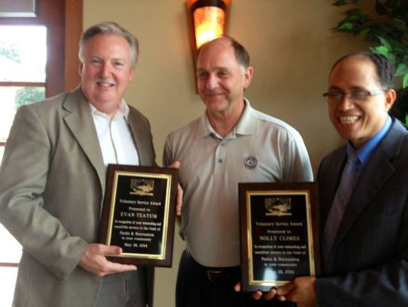 Evan Teatum of Goshen, left, and Nolly Climes of Campbell Hall, right, were honored by the Hudson Valley Leisure Services Association recently. Here they are presented with their awards by Tom Quinlisk of Orange County Parks.