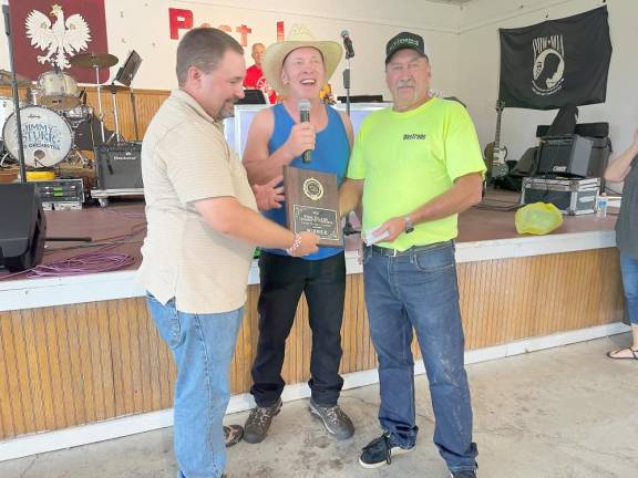 Winner of the Onion Eating Contest Ray Wesolowski receives a plaque and $100. He has triumphed in previous onion eating contests.