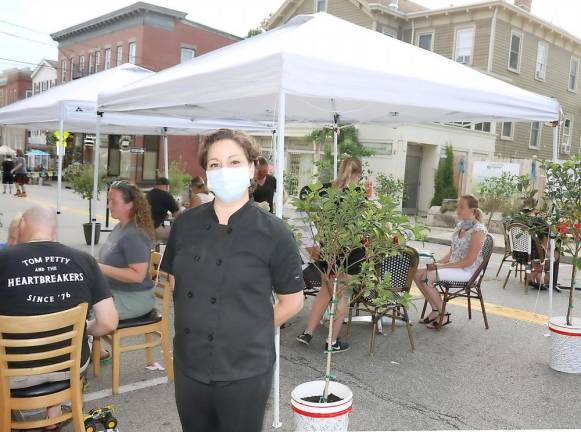 Sarah Carew, manager of Wolfe’s, wears a mask, which seated diners can remove.