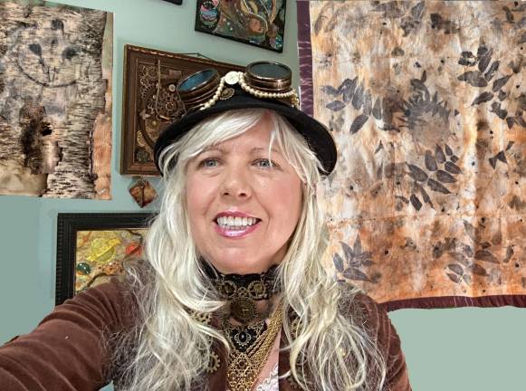 Sharon ShaZam Roll poses in front of her art.