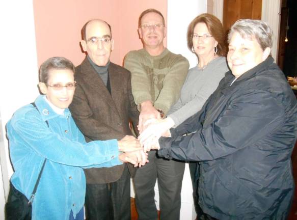 Photo by Stan Martin Warwick Rotary President Neil Sinclair, center, joins in a &quot;community teamwork handshake&quot; with food pantry representatives at last week's Rotary meeting at the Landmark Inn. Participating in the gesture of unity in feeding needy families are Susan and Glenn Dickes from the Warwick Ecumenical Food Pantry, Sinclair, Mary Jean McHugh, vice president of the Greenwood Lake Food Pantry, and Denise Thibault, Florida Food Pantry director.