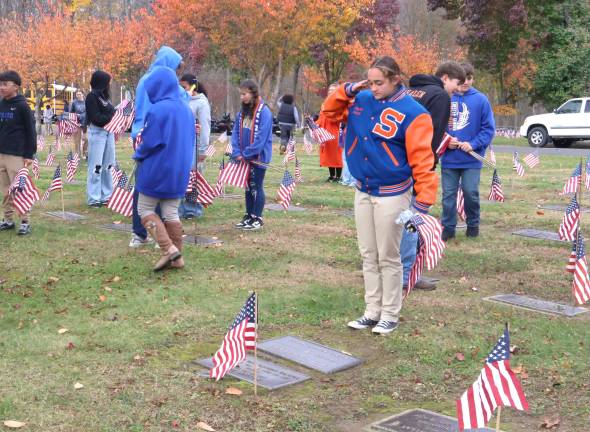 After placing each flag at the Veterans Cemetery, S.S. Seward JROTC cadets read aloud the name of each veteran and saluted.