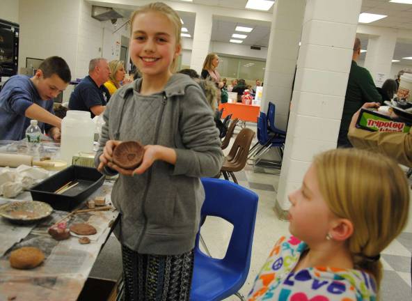 Photos by Louise Hutchison This student is proud of the clay bowl she just made and decorated at Empty Bowls.