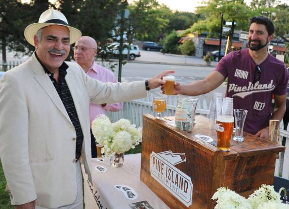 Daniel Sarno (right), event manager for Pine Island Brewing Company, serves a craft beer to Warwick businessman Moshe Schwartzberg.