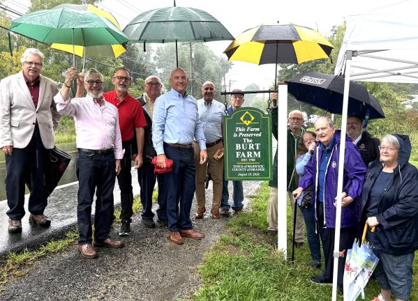 From left to right: Deputy Town Supervisor, Russ Kowal; Village of Warwick Michael Newhard; Town Councilman, Tom Mattingly; Village of Greenwood Lake Mayor, Tom Howley; Warwick Town Supervisor, Jesse Dwyer; Town Attorney, Robert Krahulik, Esq.; Town Councilman, Floyd DeAngelo; Danny McFarland; Abigail McFarland; Don McFarland; George Opper; Carol McFarland Stearn. Not shown were Town Police Department Officers, Sean McNamara and Brian Siniscalchi; and Tony Donato, who produced the sign.