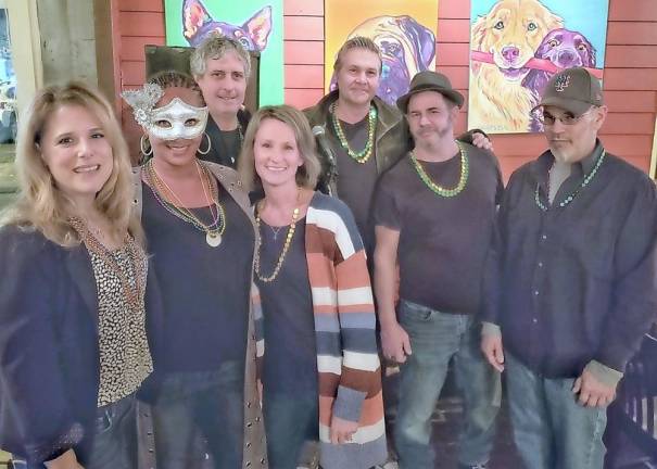 Frank Sorino and band mates of the Bomb Squad take a break with Mardi Gras volunteers at Fetch. They were one of 15 acts involving 66 musicians at 13 venues who donated a total of $5,400 of in kind performances. All Music was provided pro bono for Backpack Snack Attack.