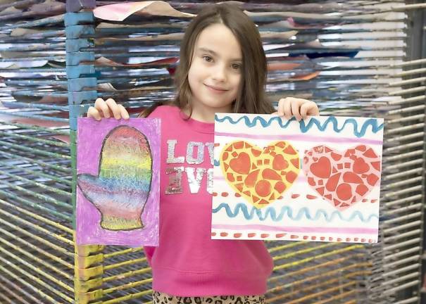 Sanfordville Elementary School second grader Cate Jacob holds up two examples on her artwork.