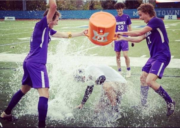 Captain Joe Holder and Carson Rother give Coach Dennis O’Connor the celebratory ice water treatment. Provided photo.