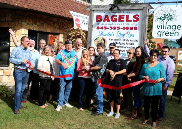 Photo by Roger Gavan On Wednesday, Oct. 11, Greenwood Lake Mayor Jesse Dyer (far left) and members of the Warwick Valley and Greenwood Lake Chambers of Commerce joined owners Christine and Will Moley (center), local residents, employees, family and fiends to celebrate the grand opening of Greenwood Lake Bagels with a ribbon-cutting ceremony.