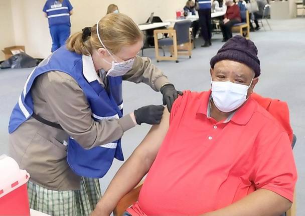 Carrie Johnson, a volunteer nurse from the Bruderhof Community in Walden, administers a vaccination to Middletown’s David Heath.