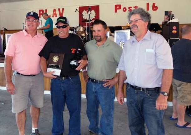 Pine Island Chamber President Leonard DeBuck. left, stands with onion-eating contest winner Ray Weslowski, Vegetable Growers President Paul Ruszkiewicz and contest Chairman Russell Kowal.