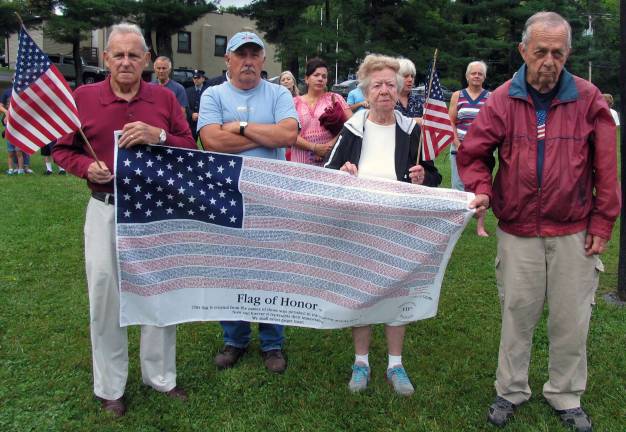 Photos by Roger Gavan The Flag of Honor contains the names of those who perished in the attack. From left, Patrick Colman, Mike Demarmels, Anita Colman and Bob Hogan.