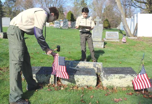 Troop 38 Scouts Dan Jackson (left) and Thomas Kanz helped veterans place flags at St. Stephen&#x2019;s Cemetery.