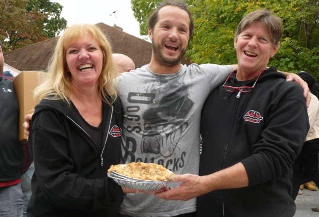 Winner of the adult Pie Eating Contest, Eddie Cullari of Warwick, finished his large apple pie in 3:17. Eddie is congratulated by Leslie Noble and Tom Hermann of Noble Pies.