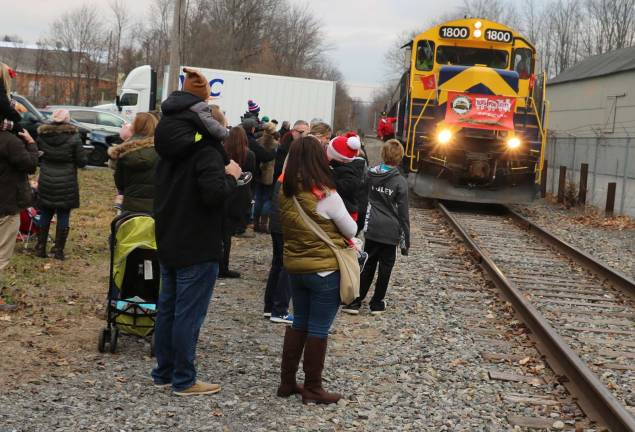 Photos by Roger Gavan On Sunday afternoon, Dec. 3, a large crowd had gathered in the Chase Bank parking lot as Middletown &amp; New Jersey Railroad Engineer Josh Shields drove a diesel locomotive pulling a train of railroad freight cars along with passenger compartments into the Village of Warwick.