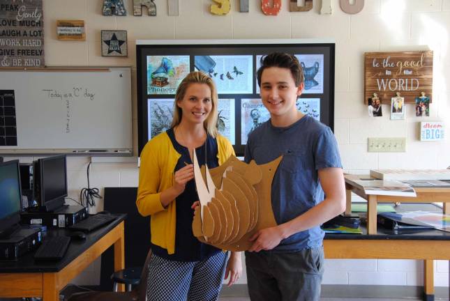 Photo by Louise Hutchison Warwick Valley High School art teacher Kristen Spano with senior Daniel McQuade, holding his 3-D rhino head made of recycled cardboard.