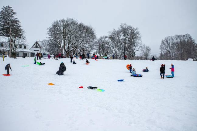 Kids and adults alike, adorned in their colorful snow gear, flocked to the hill in the park for some afternoon sledding.