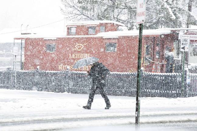 Photo by Robert G. Breese A traveler makes his way through the Village of Warwick during the early moments of the storm.